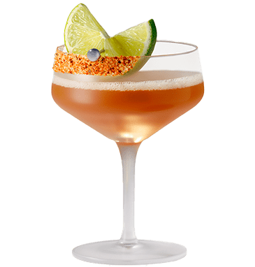 A Tamarind Twist cocktail in a coupe glass with tajin on the rim