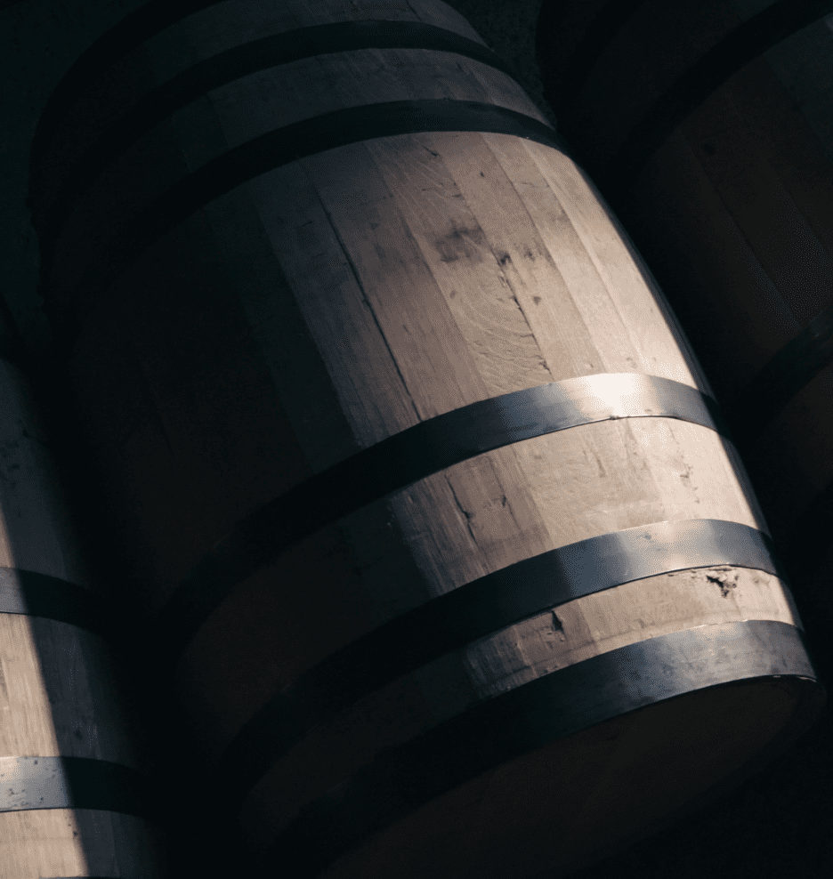 Wooden barrels with metal bands in a dimly lit storage room